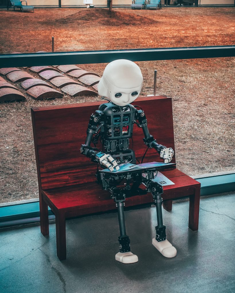 Robot avec tablette numérique illustrant un chatbot