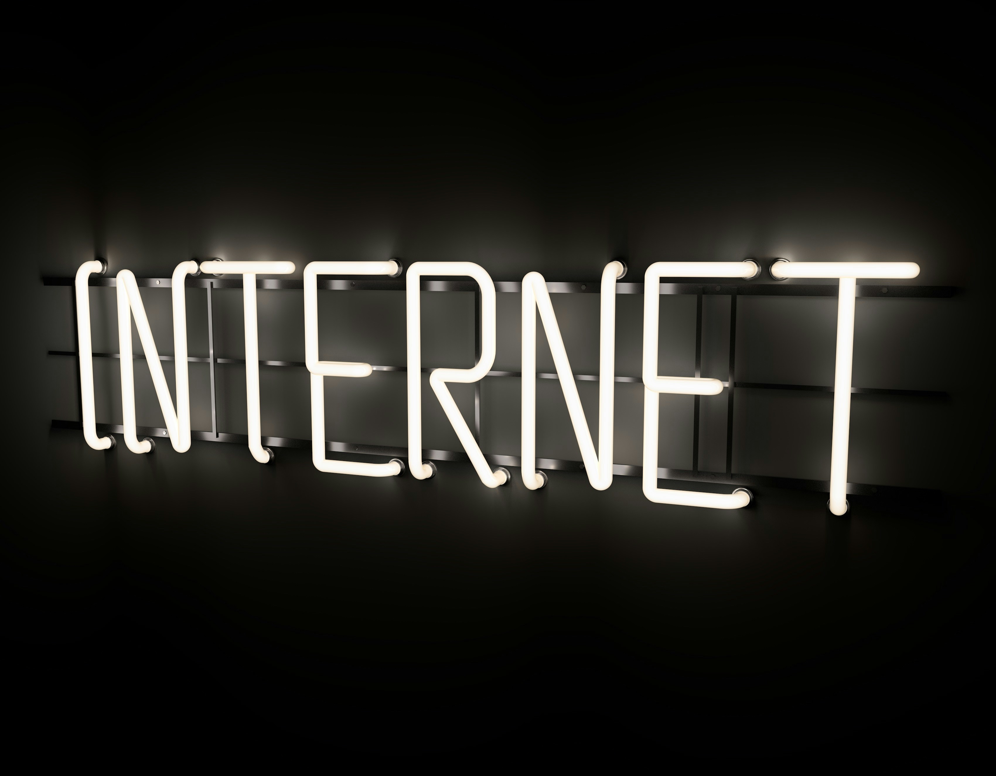 Affiche lumineuse avec le mot "Internet" écrit en lettres néon blanches sur un mur sombre, symbolisant l’esthétique numérique et futuriste du Web.
